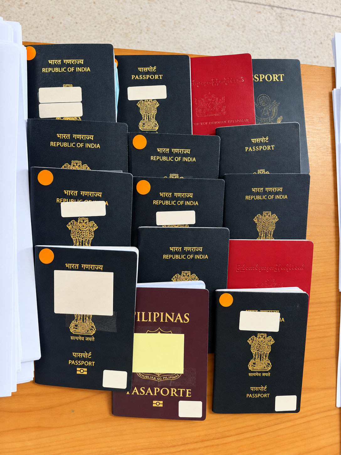 Closed passports on a desk with all handwritten labels obscured
